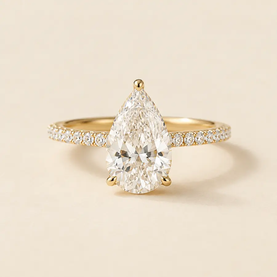 Pear shaped diamond engagement ring on a thin micro pavé yellow gold band